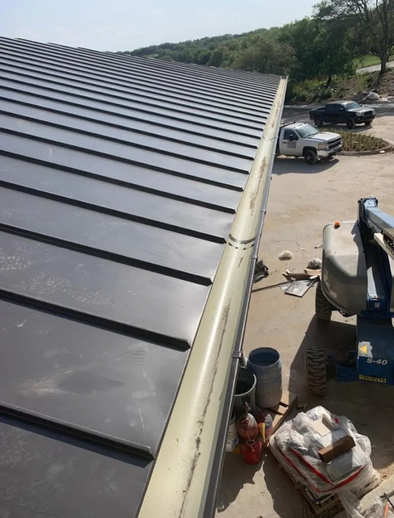 Standing seam panel and gutter detail on a metal roofing jobsite in Mims
